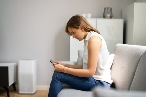 Woman With Neck Pain Sitting Using Mobile Phone