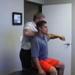 Dr. Michael Bell adjusts a client's shoulder to relieve pain and increase mobility.