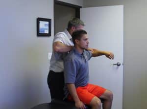 Dr. Michael Bell adjusts a client's shoulder to relieve pain and increase mobility.