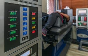 The digital panel of the DRX 9000 Spinal Decompression machine while a patient receives therapy in the background.