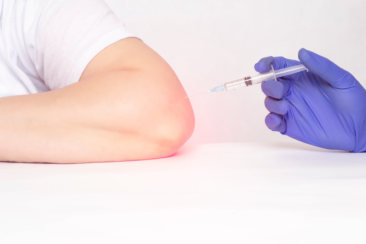 A patient experiencing elbow pain about to receive an ozone injection to aid with healing and pain management.
