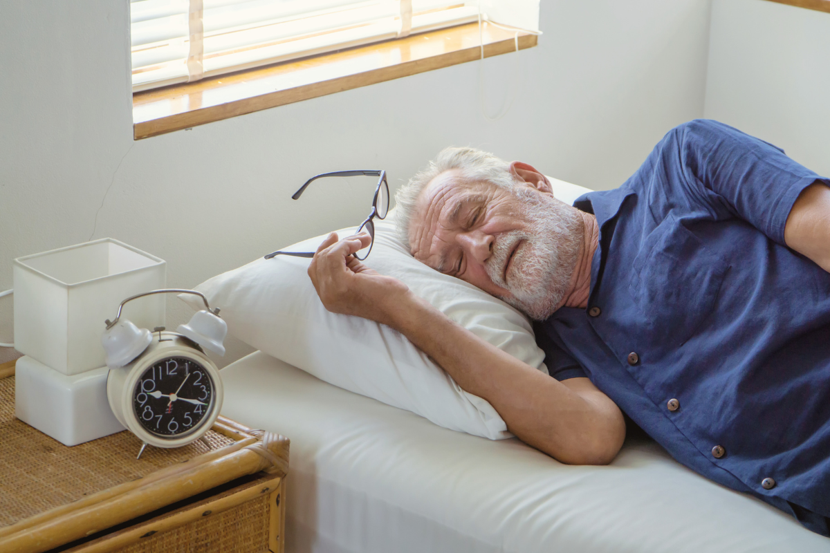 A healthy elderly man sleeping in a peaceful bedroom. 