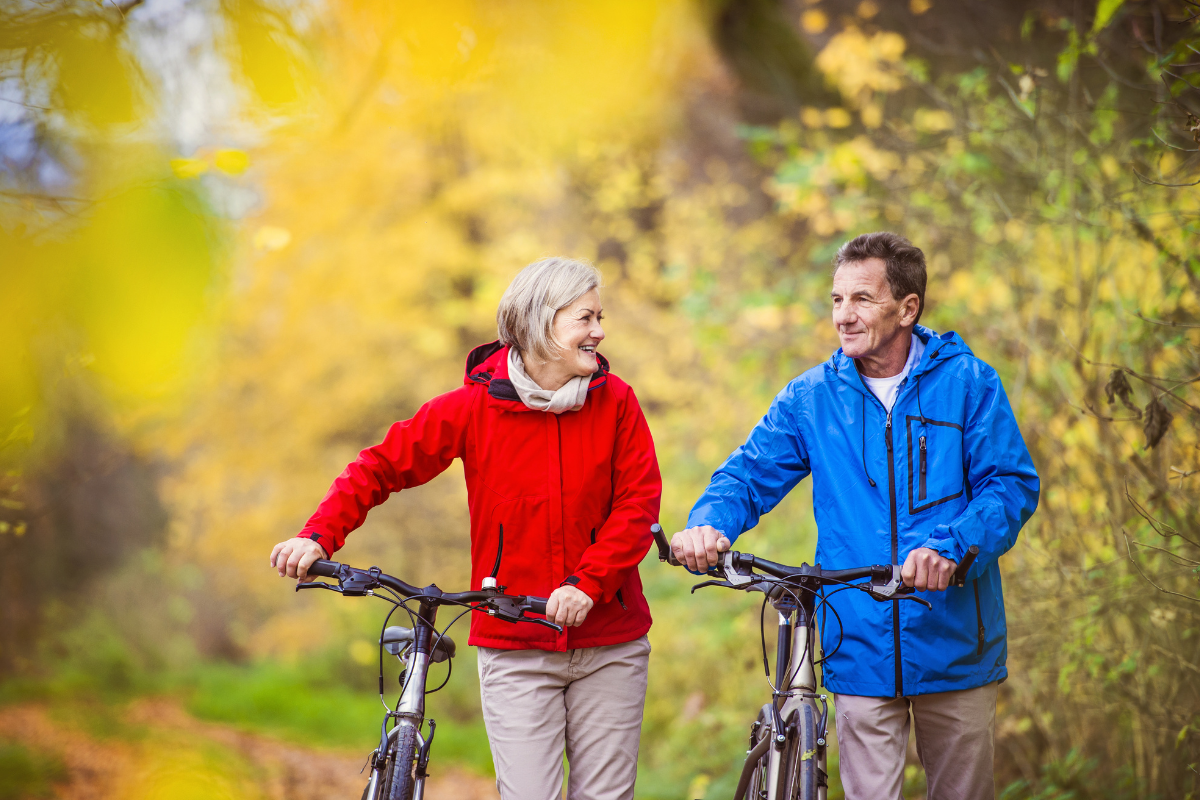 A midde aged couple staying healthy by going on a bike ride together in a beautiful outdoor setting.
