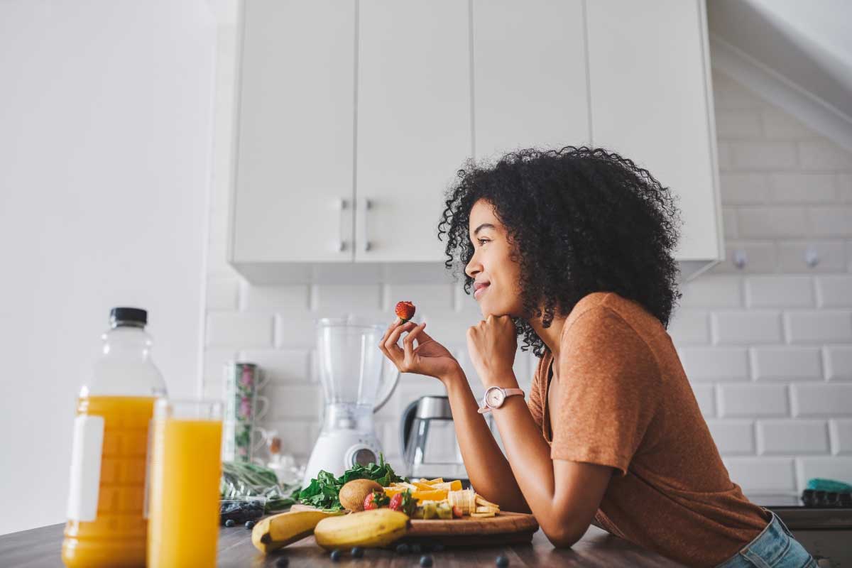 A woman eating a healthy meal feeling good about her digestive health. 