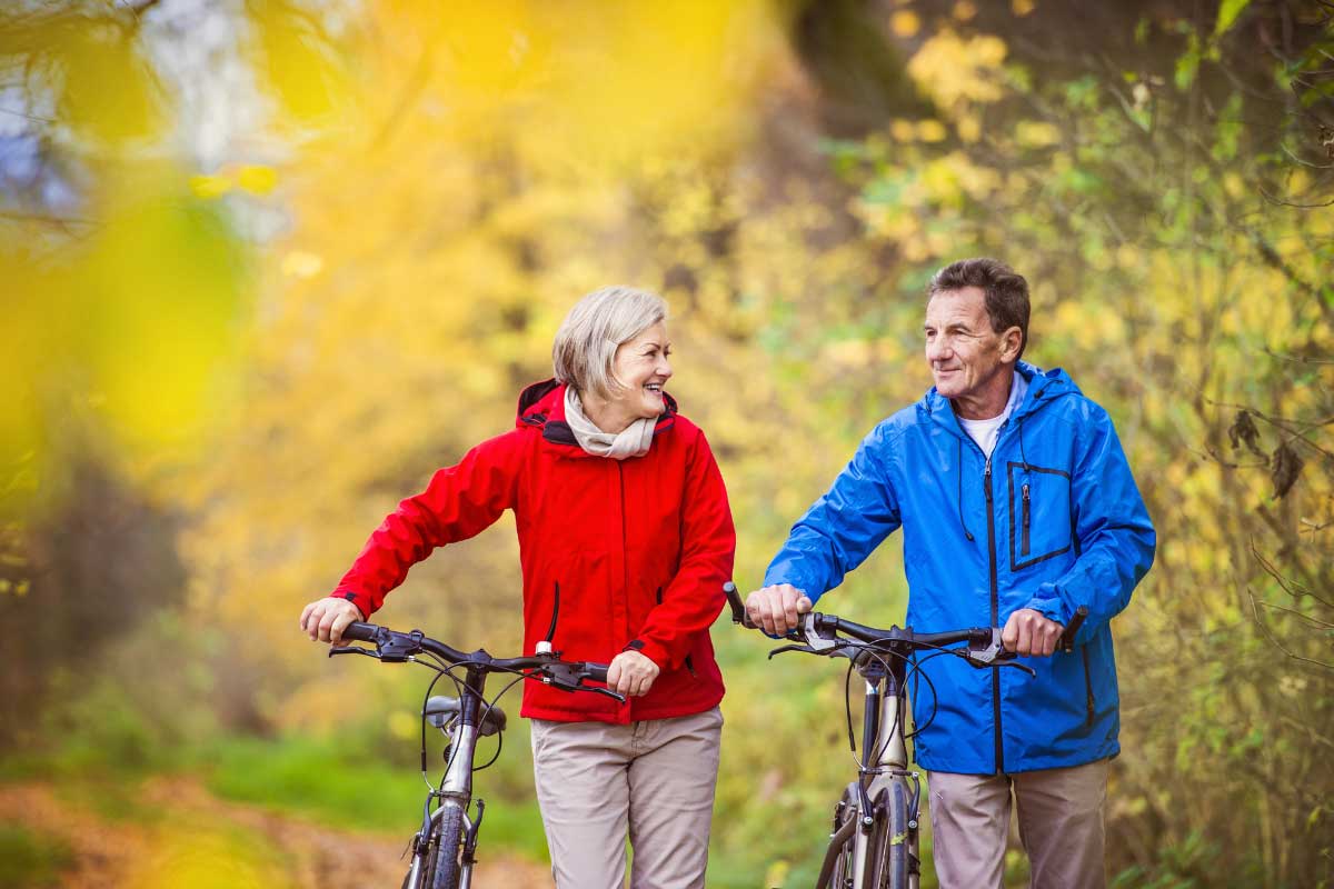 Optimal Health with Functional Medicine 3 A midde aged couple staying healthy by going on a bike ride together in a beautiful outdoor setting.
